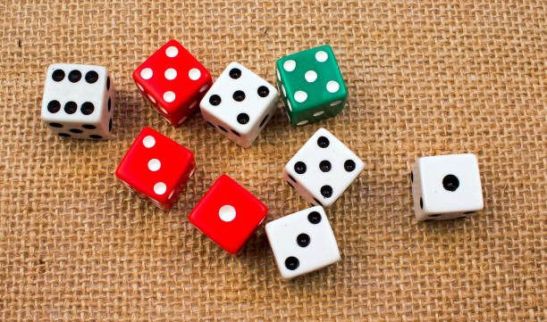 istock Several Random Red, White and Green Dice Cubes on a Burlap Background 911469288