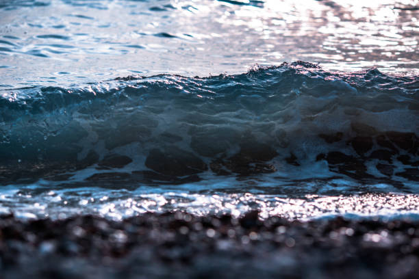 istock tide of waves on a stone beach 911474430