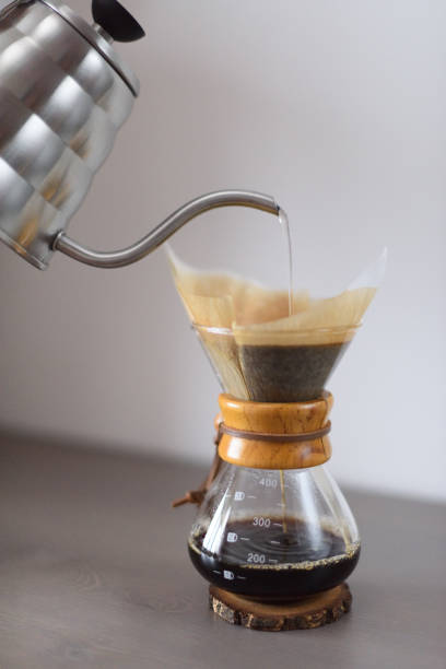 istock Making pour over coffee minimalistic style. Pouring hot water from kettle into drip coffee maker with filter 911475134