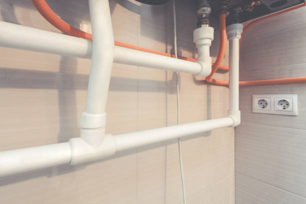istock White plastic water pipes of plumbing system and double electrical socket on the wall with ceramic tiles. Picture with tone effect. 911483432