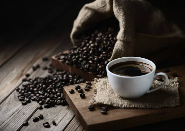 tasses à café et grains de café sur une table en bois - Photo