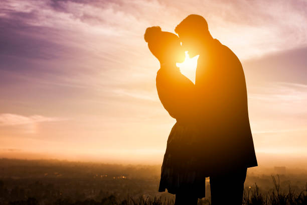 Diverse Couple Engagement Silhouettes at Sunset A beautiful diverse couple gets engaged at sunset black couple silhouette stock pictures, royalty-free photos & images
