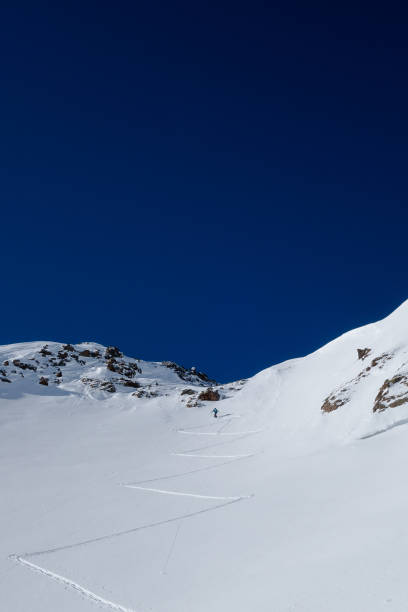 istock Skier leading way up steep slope to alpine mountain pass 911490232