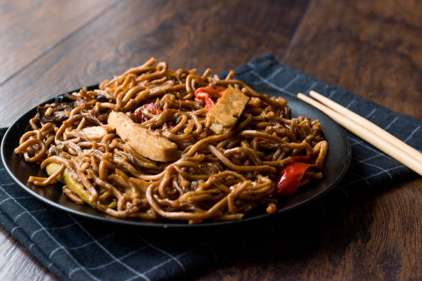 istock Veggie Noodle with Tofu and Red Peppers on Black Plate 911491366