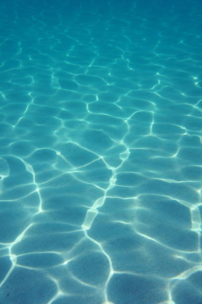 istock Underwater sunlight on the sand of ocean floor 911491388