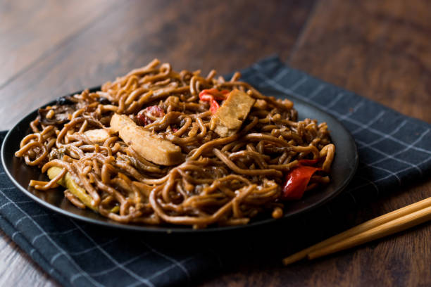 istock Veggie Noodle with Tofu and Red Peppers on Black Plate 911492750
