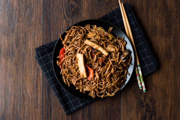 istock Veggie Noodle with Tofu and Red Peppers on Black Plate 911493956