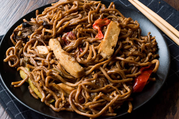 istock Veggie Noodle with Tofu and Red Peppers on Black Plate 911494216