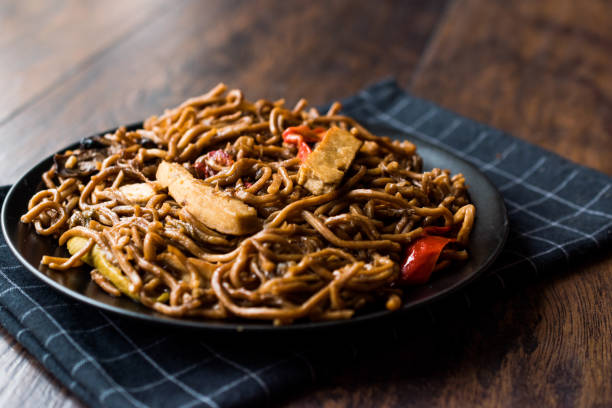 istock Veggie Noodle with Tofu and Red Peppers on Black Plate 911494726