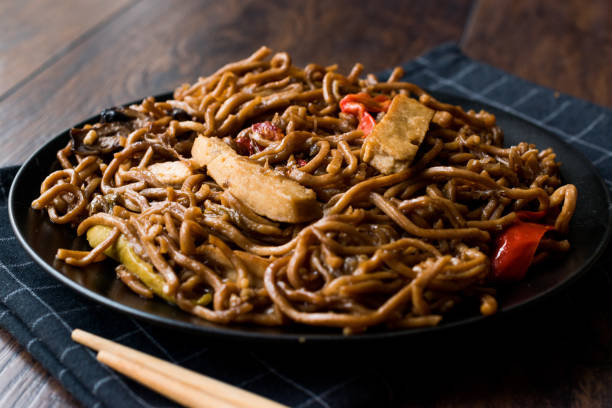 istock Veggie Noodle with Tofu and Red Peppers on Black Plate 911496916