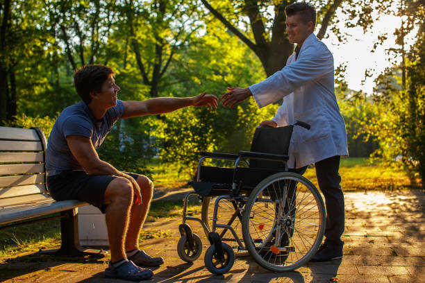 istock Young doctor helping one guy to stand up. 911507340