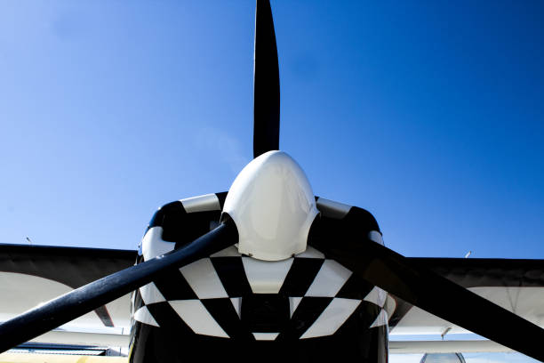 istock Black Propeller on a Black and White Airplane Agaist a Bright Blue Sky 911519692