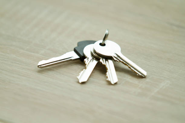 Keys to the front door of the house. Various accessories needed to protect your home from theft. Light background.