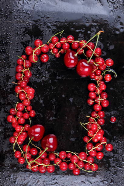 istock Red currant and cherry on a black background, red berries on a metallic retro background, healthy food, vegan, currant berries for cooking, cherry on an old background 911522456