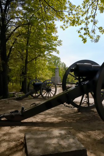 The Little Roundtop Monument is seen over civil war period cannons at the Gettysburg National Battlefield