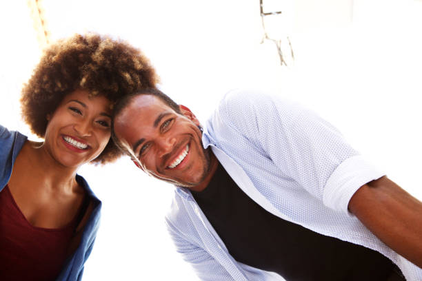 istock Beautiful fun couple laughing together on white background 911536204