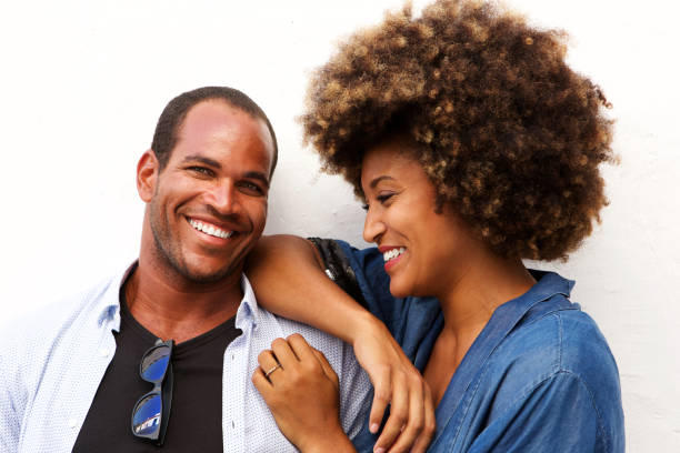istock Close up beautiful couple laughing and standing by white wall 911536218