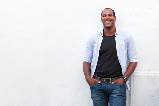 Portrait of attractive man standing and laughing on white background