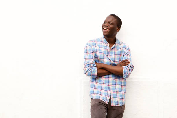 istock smiling young man with arms crossed and looking away on white background 911537232