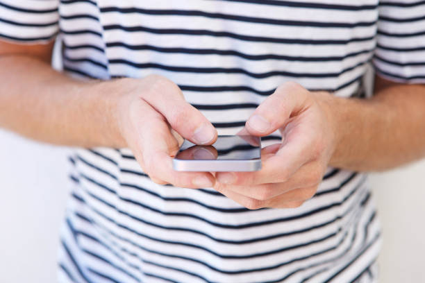 istock Close up young man holding mobile phone in hands 911538058