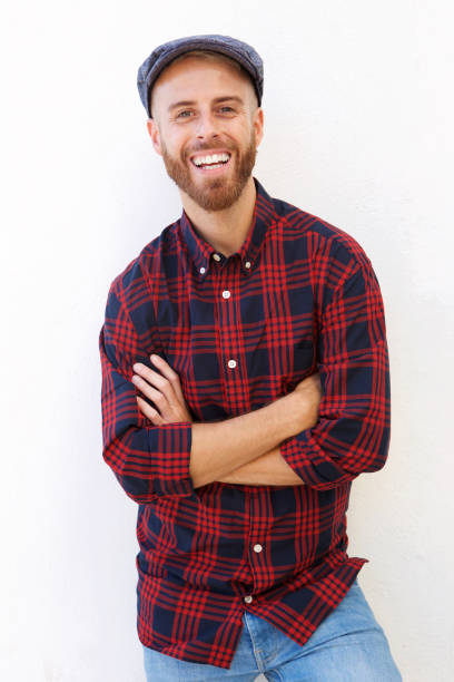 istock cool young man with hat smiling against white background 911538070