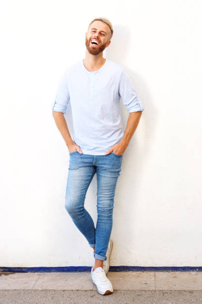istock Full length happy young man leaning against white wall 911538134