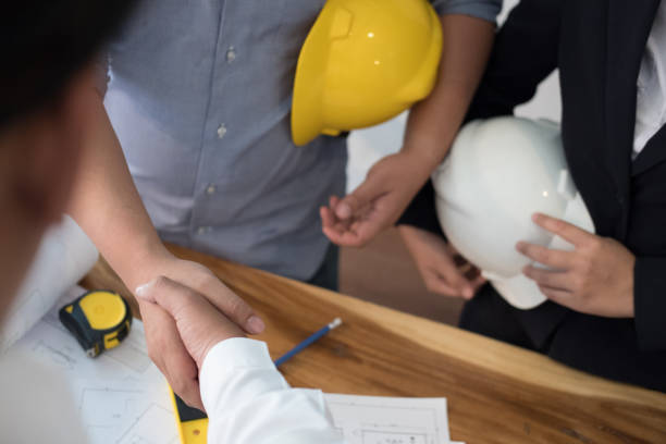 istock Architect & customer shaking hands. Engineer handshaking with partner for successful deal in building project development. business teamwork, cooperation, success collaboration concept 911549864