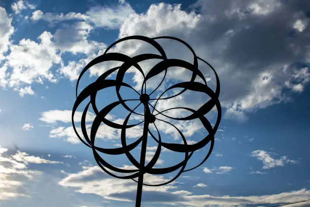 Garden Whirlygig Silhouetted Against a Blue and Cloudy Sky