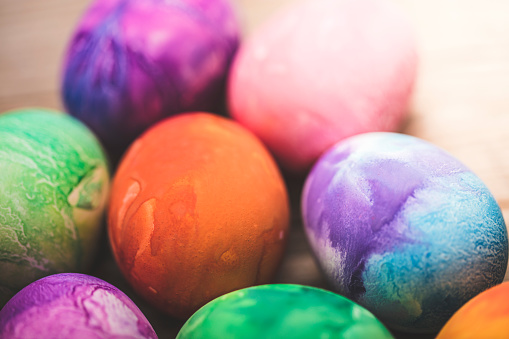 A stock photo of Dyed Easter eggs on a wood background.