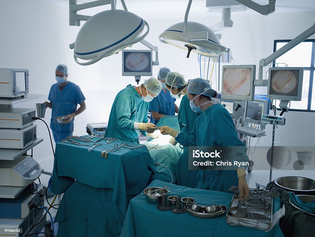 Surgeons performing operation in operating room  Operating Room Stock Photo