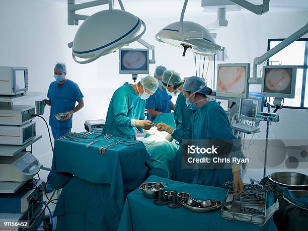 Surgeons Performing Operation In Operating Room Stock Photo - Download Image Now - Operating Room, Surgery, Doctor