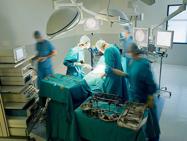 Surgeons performing operation in operating room  critical care photos stock pictures, royalty-free photos & images