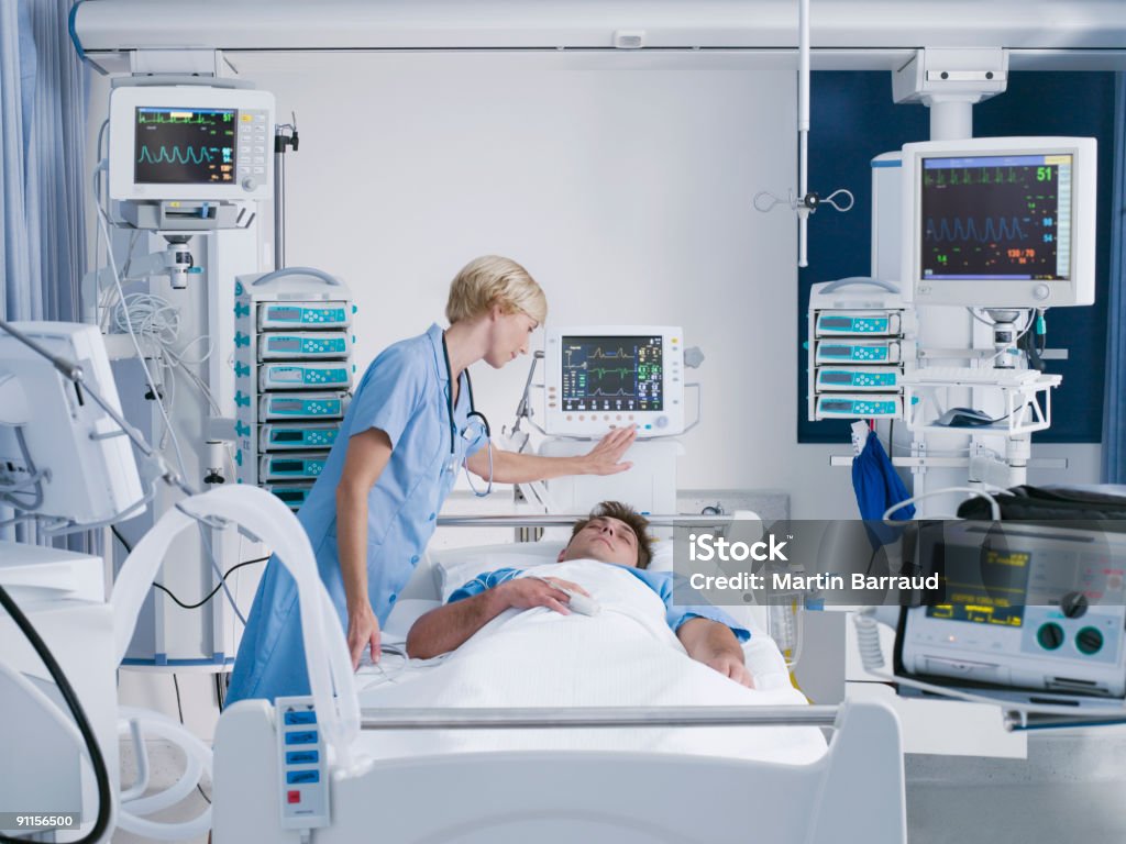 Nurse tending patient in intensive care  Intensive Care Unit Stock Photo