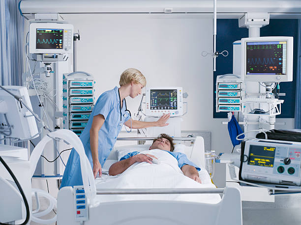 Nurse tending patient in intensive care  intensive care unit photos stock pictures, royalty-free photos & images