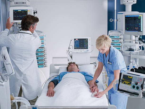Doctor and nurse attending patient in intensive care  critical care photos stock pictures, royalty-free photos & images