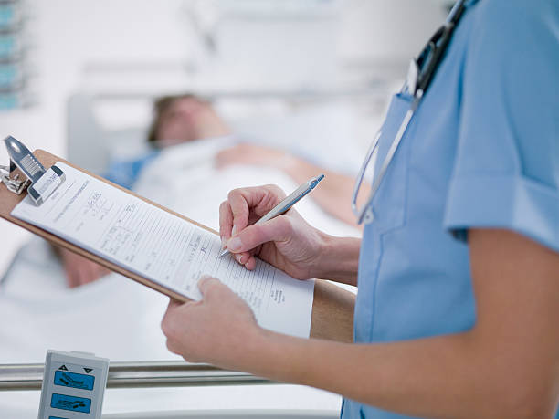 Nurse tending patient in intensive care  clipboard stock pictures, royalty-free photos & images