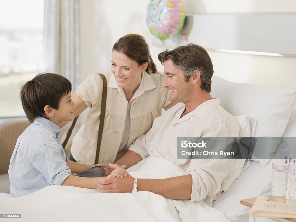 Wife and son visiting recovering husband in hospital  Hospital Stock Photo