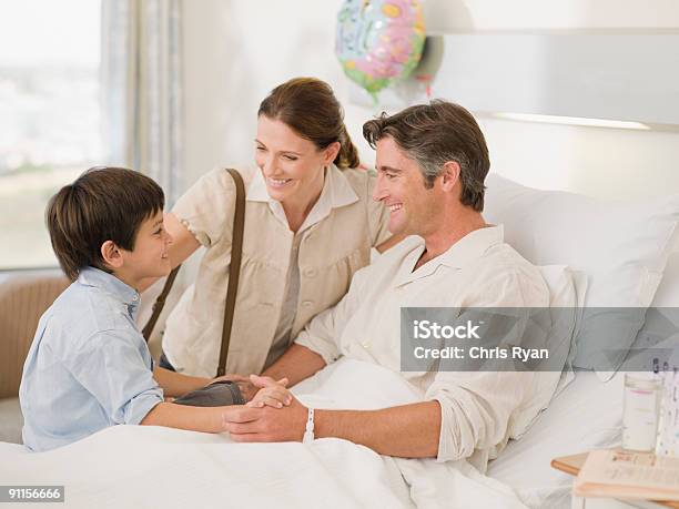 Wife And Son Visiting Recovering Husband In Hospital Stock Photo - Download Image Now