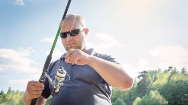 istock The man catches fish on the river bank. 911567206