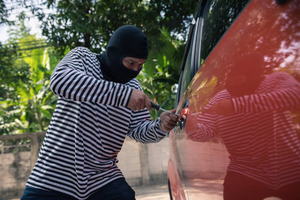 istock Car thief trying to unlock a car by screwdriver, Robber and thief concept 911570984