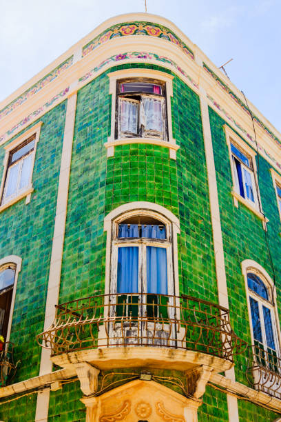 istock Mediterranean house facade with green tiles and white windows 911573980