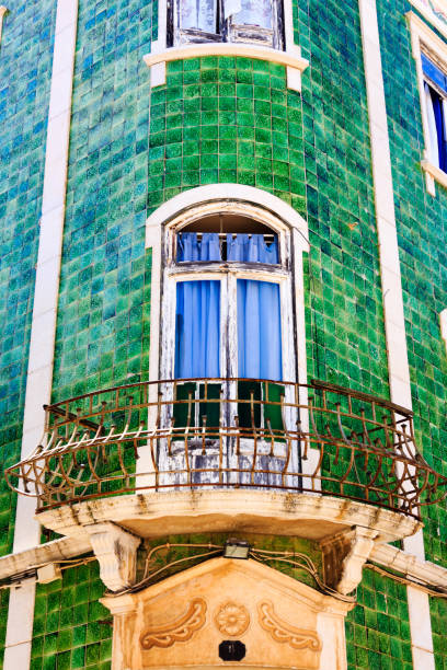 istock Mediterranean house facade with green tiles and white windows 911576208