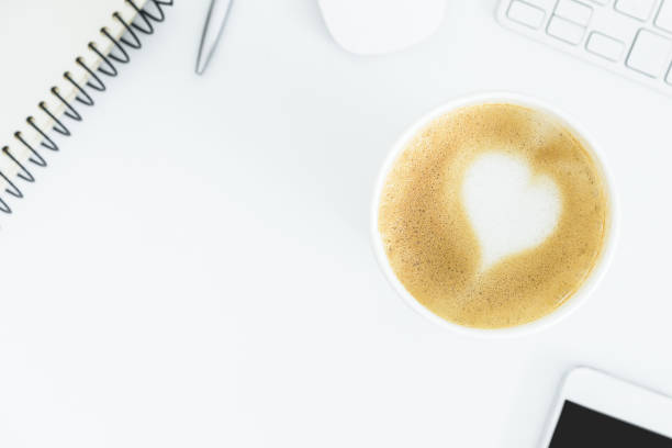 istock A latte coffee with art heart milk on the white desk table from top view and copy space. Flat lay with desk, business and valentine concept. 911587152