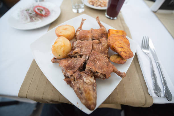 Cuy Chactado or Guinea Pig roasted on the plate served with potatoes in Peru