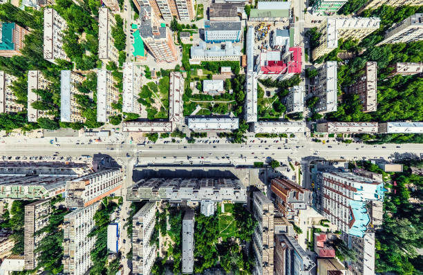 Aerial city view with crossroads and roads, houses, buildings, parks and parking lots. Sunny summer panoramic image - fotografia de stock