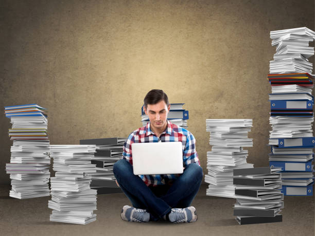 istock Male student using laptop in front of blackboard 911593194
