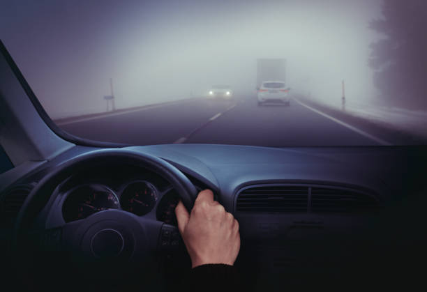 Driving in the fog View from the car during driving in bad weather with low visibility smog car stock pictures, royalty-free photos & images