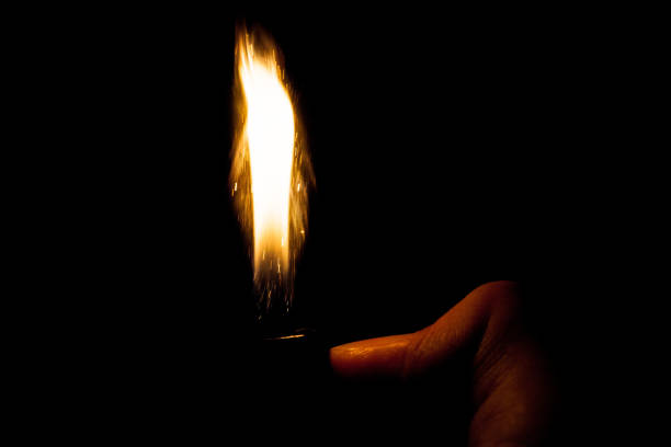 istock Close up view of real sparking light from lighter in dark black background 911611596
