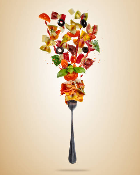 concept of flying food with fork and traditional italian farfalle pasta - fruit sauce imagens e fotografias de stock