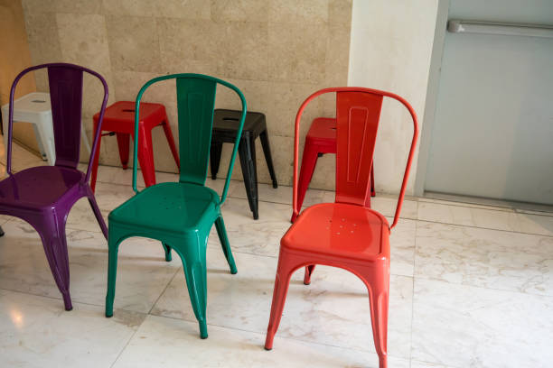 istock Empty red, green, black, white and purple metal chairs with shadow 911618114